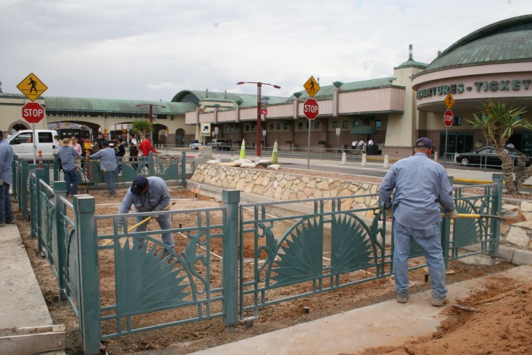 Workers clean up the pet-relief area outside El Paso International Airport.